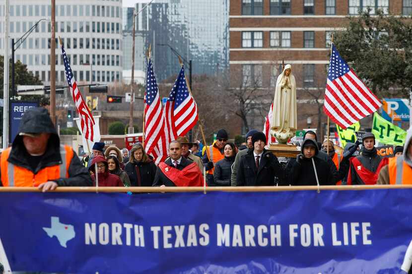 Marchers walk along Jackson St. during the North Texas March for Life, celebrating the...