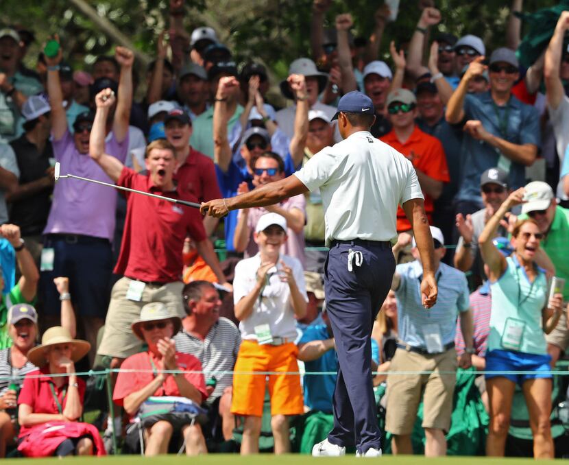Spectators react as Tiger Woods birdies No. 6 during the second round of the Masters golf...