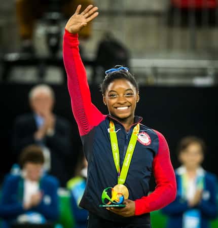 Simone Biles of the United States waves to the crowd after receiving her gold medal for the...