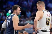 Dallas Mavericks guard Luka Doncic (77) offers his hand to shake with Denver Nuggets center...