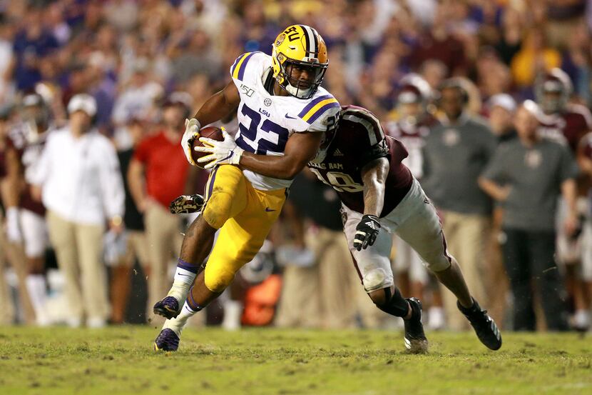 Clyde Edwards-Helaire (22) of the LSU Tigers is tackled by Anthony Hines III (19) of the...