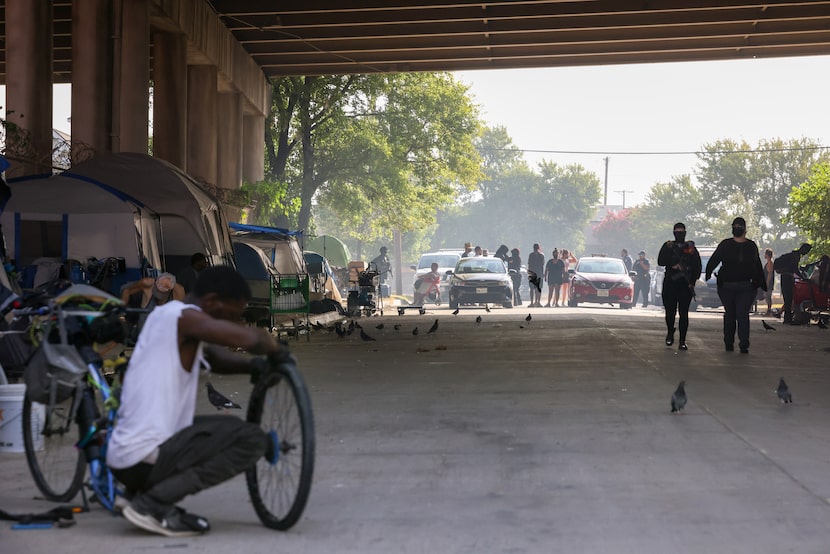 Police, city employees and activists gather at the opening of a homeless camp under a...