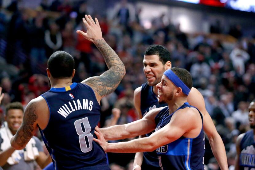 Dallas Mavericks' Deron Williams (8) celebrates with Seth Curry, right, and Salah Mejri...