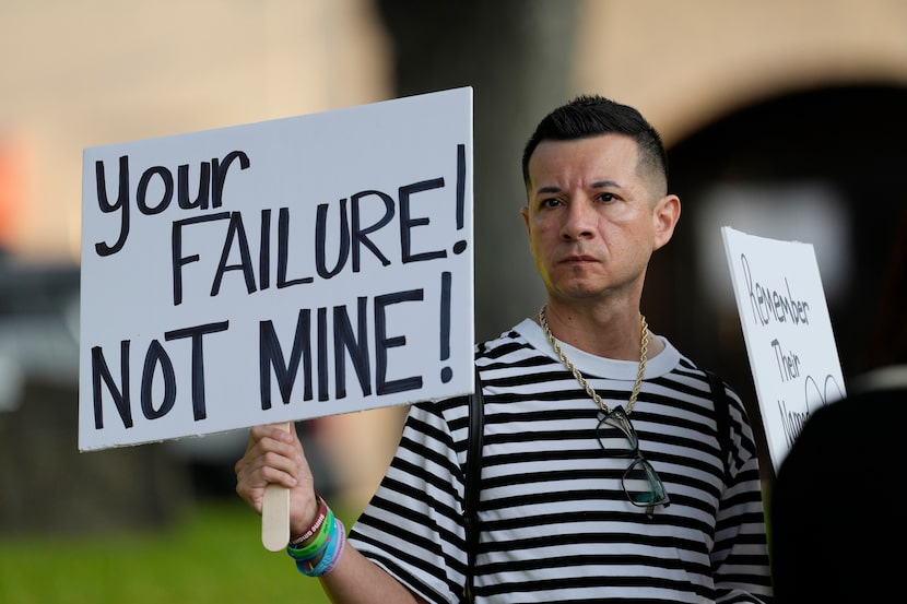 James Alvarado holds signs outside of the Uvalde County Courthouse as he shows his support...