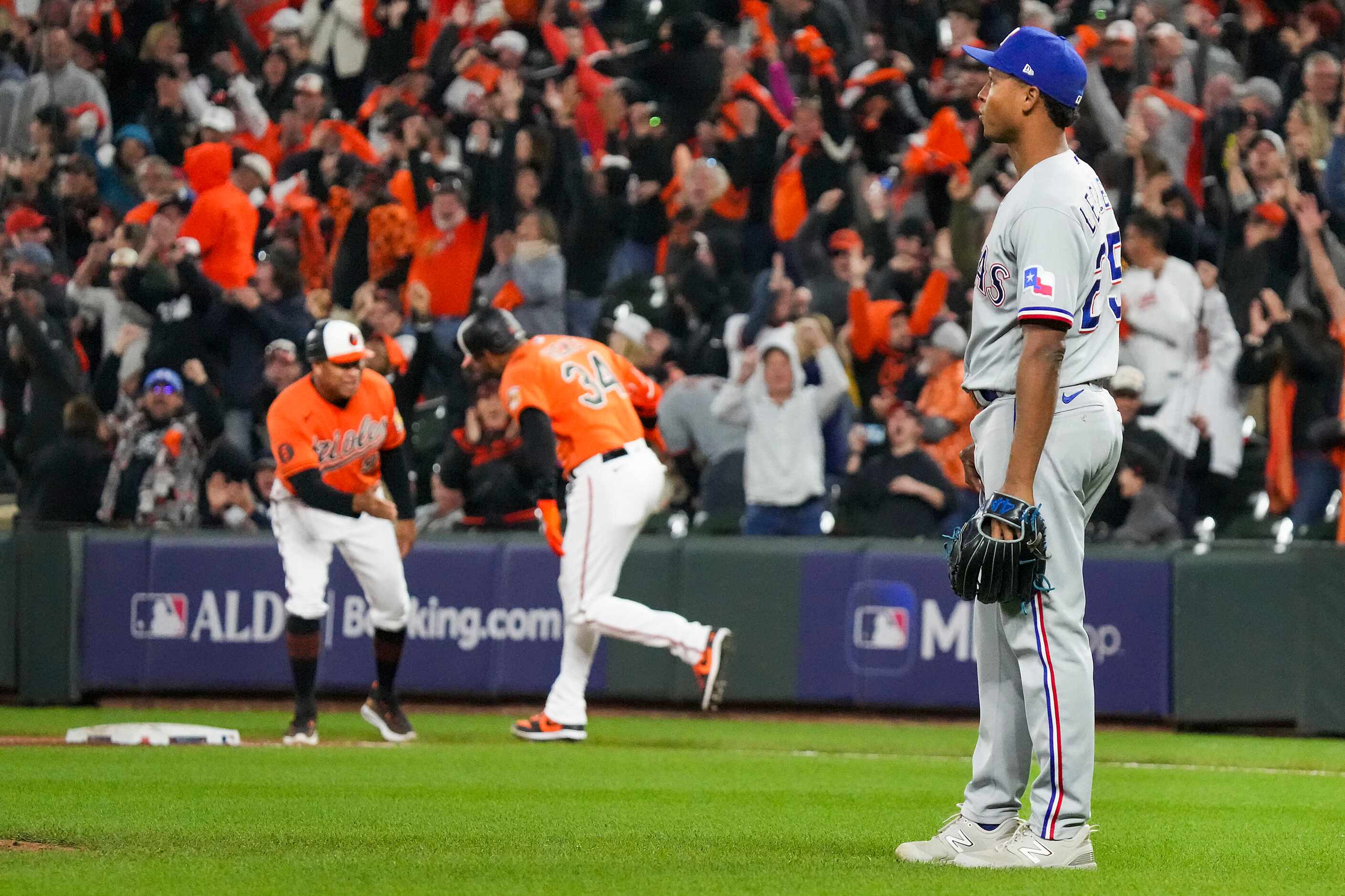 Texas Rangers relief pitcher Jose Leclerc looks back as Baltimore Orioles right fielder...