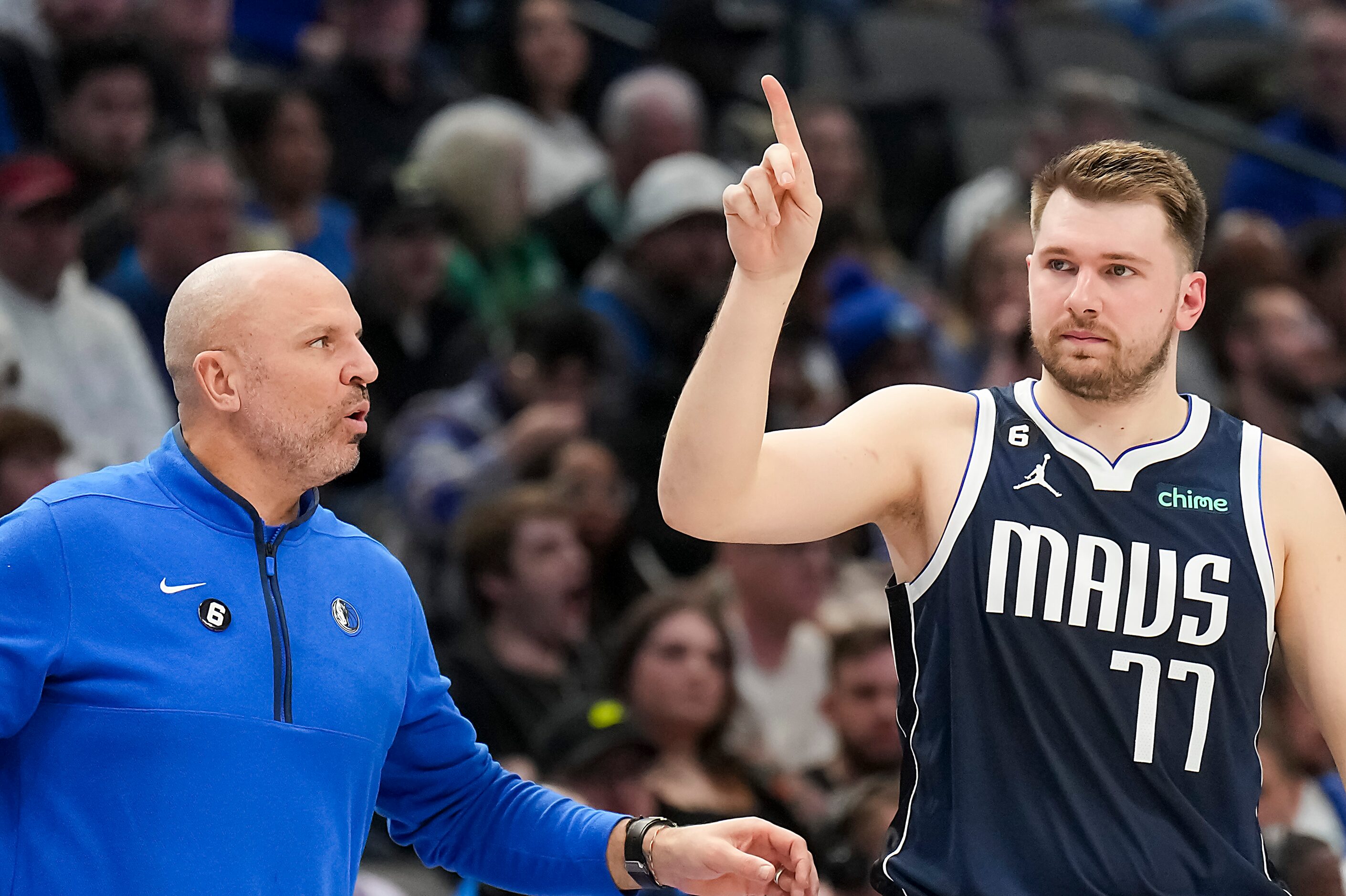 Dallas Mavericks head coach Jason Kidd talks with guard Luka Doncic (77) as he checks into...