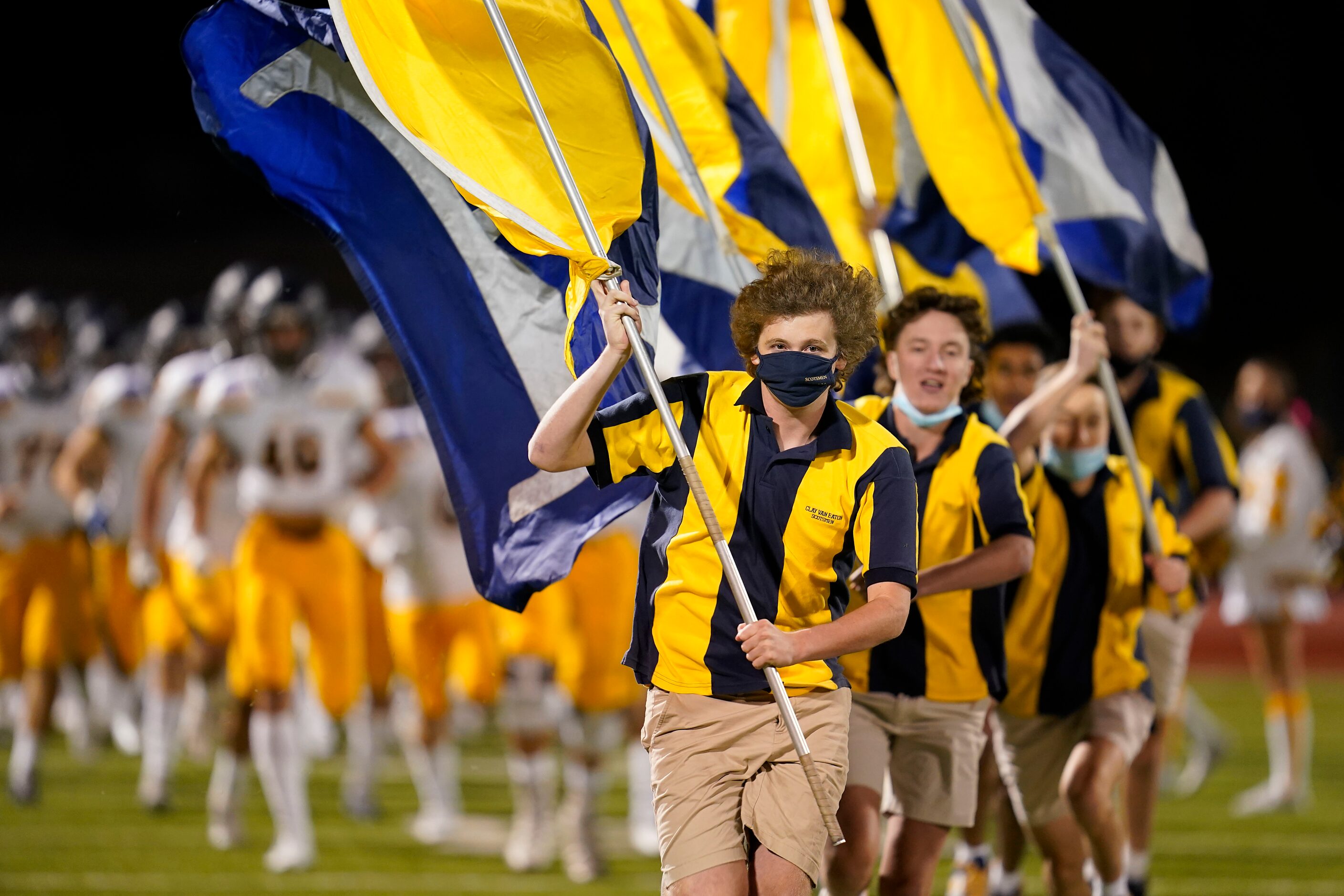 Highland Park Scotsmen lead their team onto the field before a high school football game...