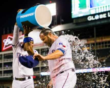  Elvis Andrus pours a cooler of water over the head of Rangers pitcher Colby Lewis after he...