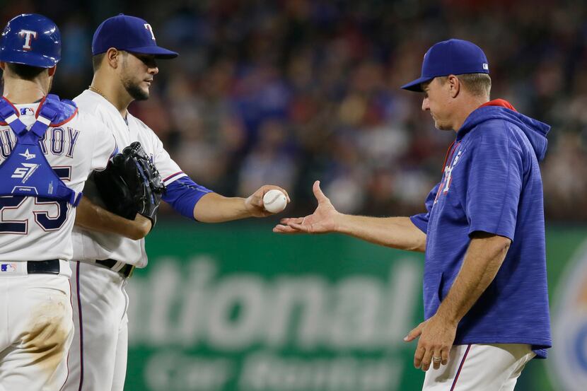 Texas Rangers manager Jeff Banister, right, pulls starting pitcher Martin Perez from the...
