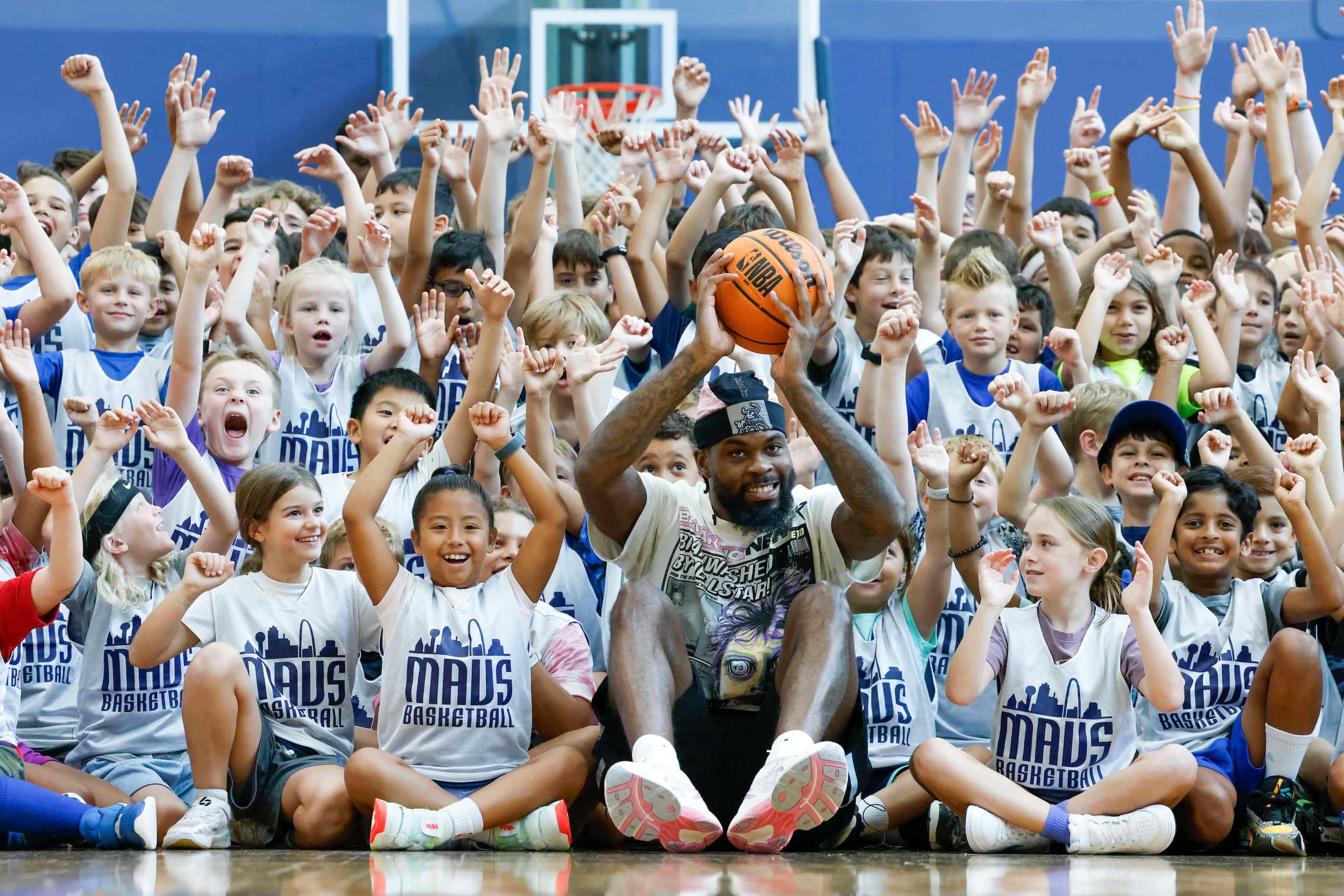 Dallas Mavericks’ Naji Marshall, cheers with young basketball campers during a Hoop Camp,...