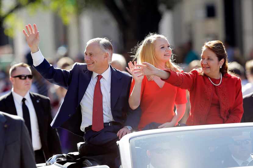 Texas Gov. Greg Abbott (left), with daughter Audrey (center) and wife Cecilia, waves during...