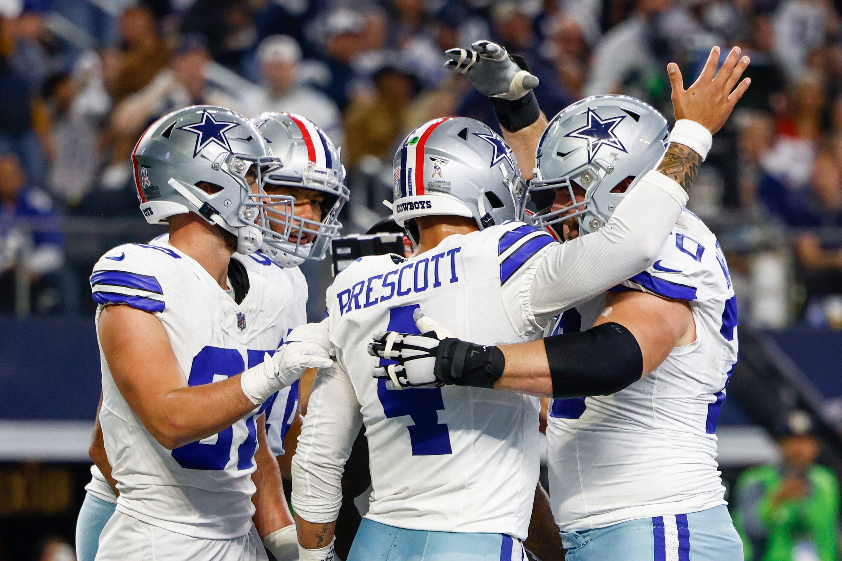 Dallas Cowboys quarterback Dak Prescott (4) is congratulated by teammates after rushing for...