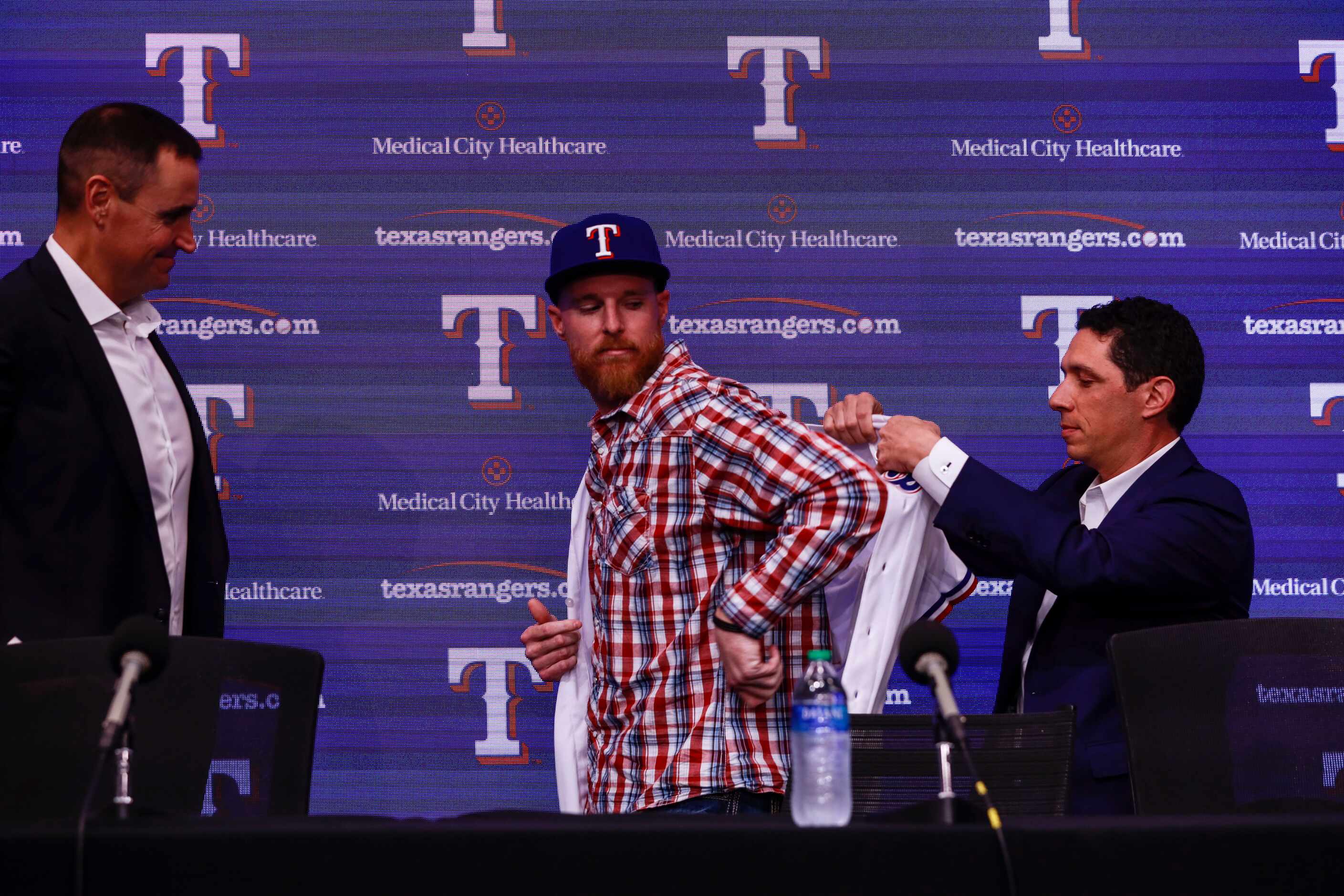 Jon Gray puts on his baseball jersey at a news conference at Globe Life Park in Arlington on...