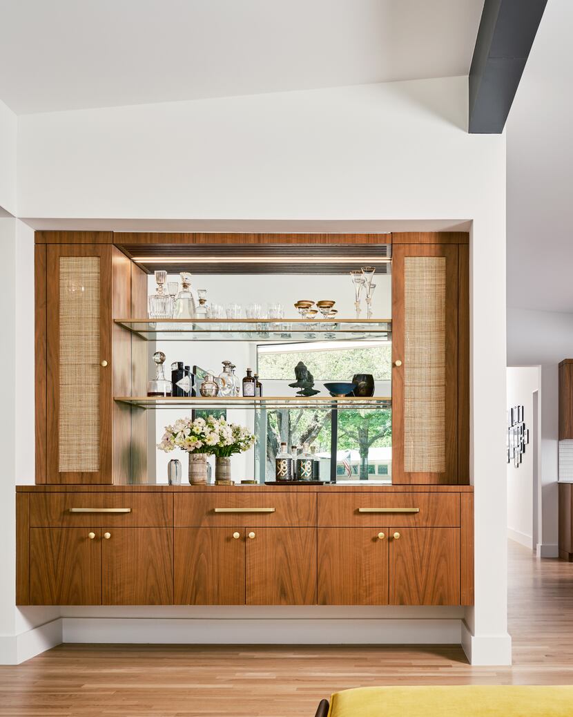 A built-in bar features walnut cabinetry and the couple's collection of vintage glassware.