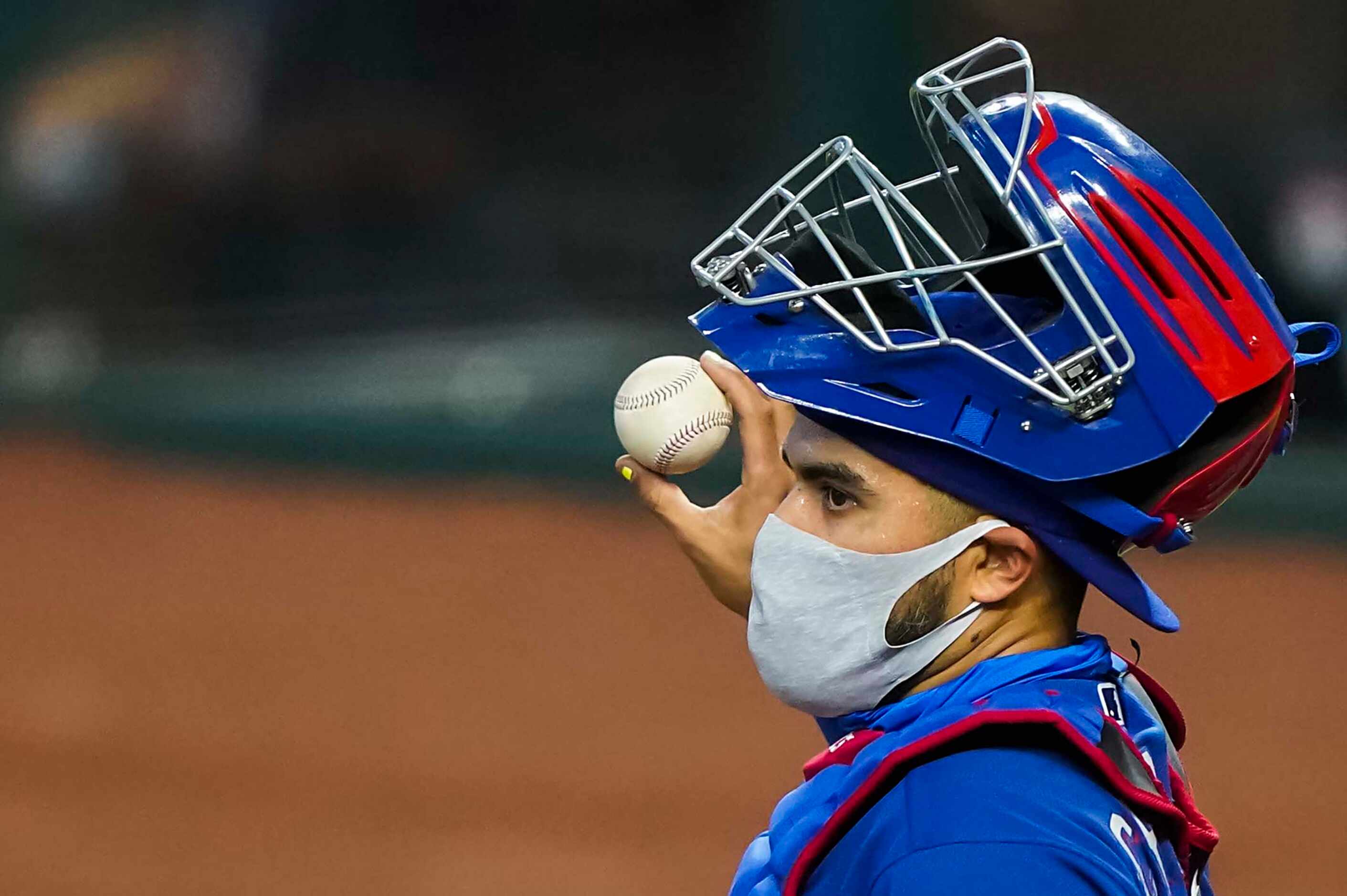 Texas Rangers catcher Robinson Chirinos wears a face mask under his mask during an...