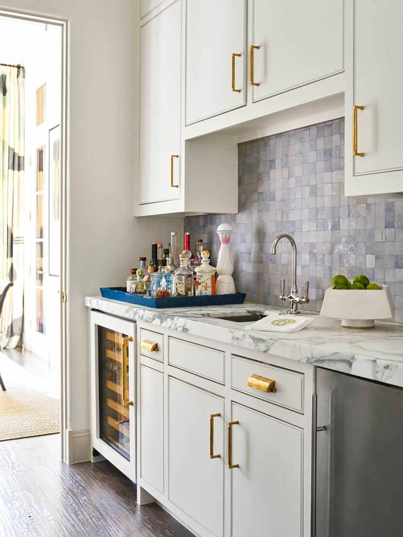 In a butler's pantry, neutral toned cabinets and marble offer a sophisticated feel. A...
