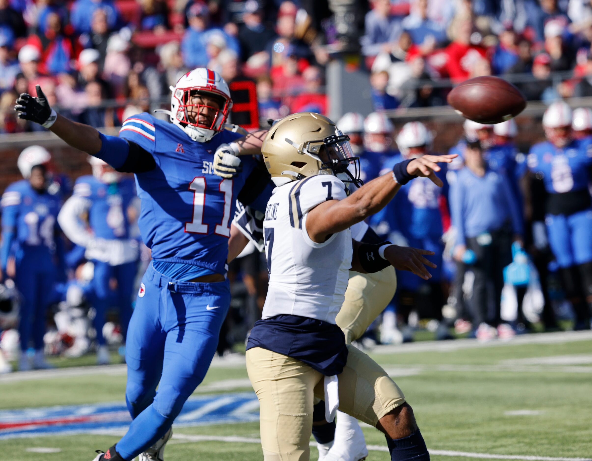 Navy quarterback Xavier Arline (7) passes under pressure from SMU defensive end Je'lin...