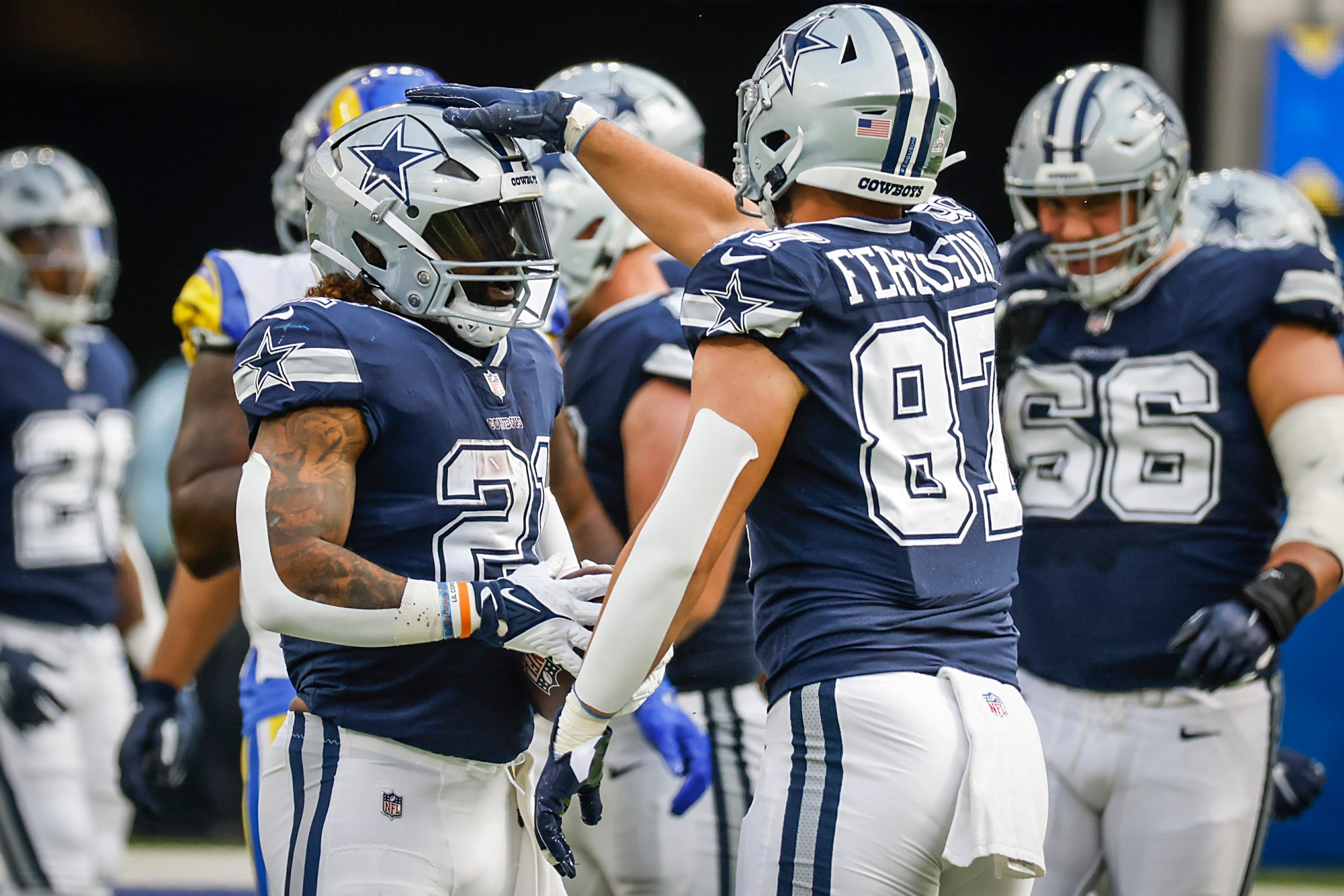 Dallas Cowboys running back Ezekiel Elliott (21) celebrates with tight end Jake Ferguson...