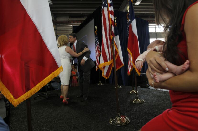 Gov. Rick Perry's family met him on stage after his announcement Monday that he will not...