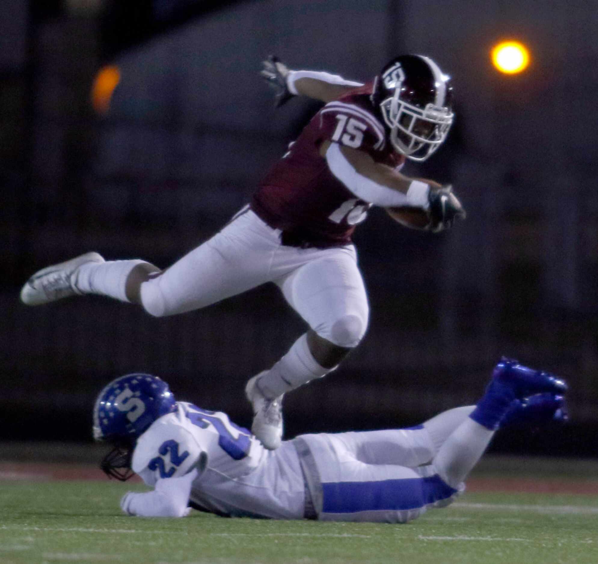 Red Oak running back C.J. Palmer (15) leaps over an attempted tackle by Seagoville defensive...