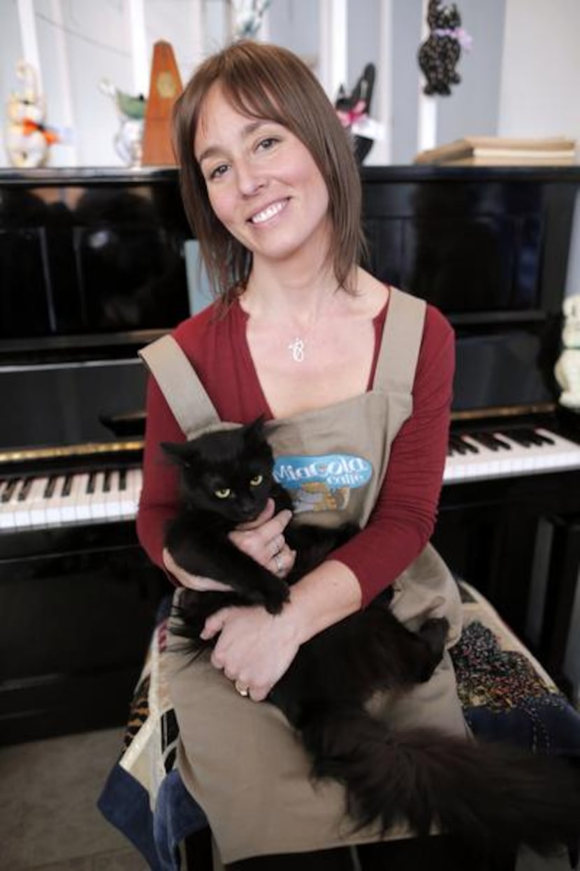 
Andrea Levine, owner and manager of the Miagola cafe in Turin poses with a cat, on March...