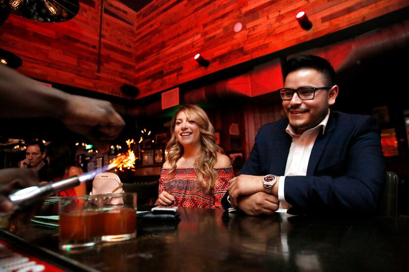 Ana Rangel and Marcos Guardado watch their cocktails get made at The Volstead Room speakeasy...