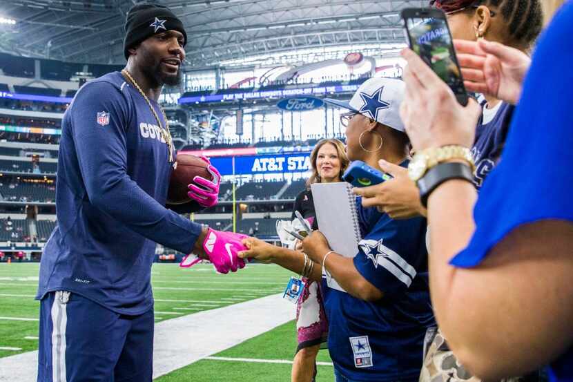 Dallas Cowboys wide receiver Dez Bryant (88) shakes hands with fans on the sideline while...