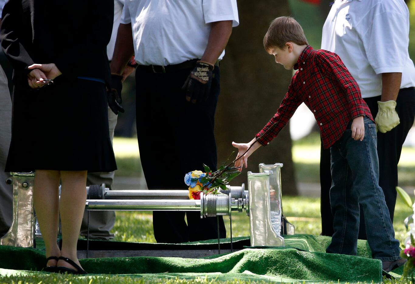 Magnus Ahrens, 8, son of fallen Dallas police officer Lorne Ahrens, drops flowers inside his...