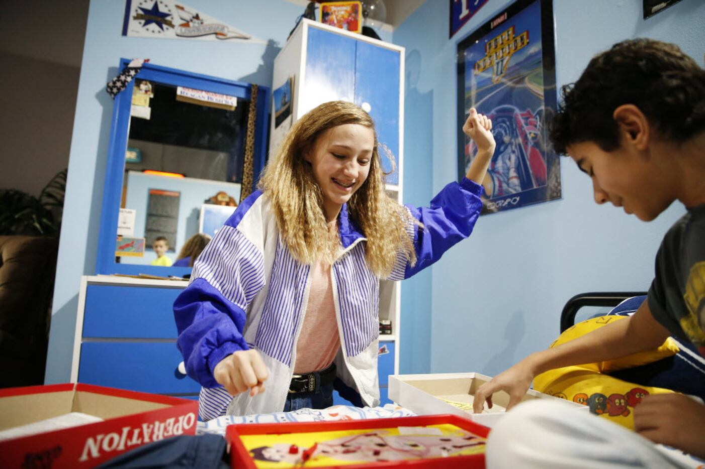 Kennedy Kellen, 14, cheers while playing "Operation" with Adrian Rivera, 13, both of Frisco,...
