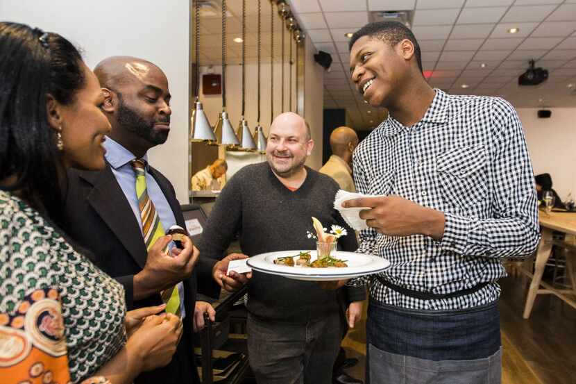 Intern Malik Runnels (right) of Pleasant Grove serves hors d'oeuvres at Cafe Momentum's...