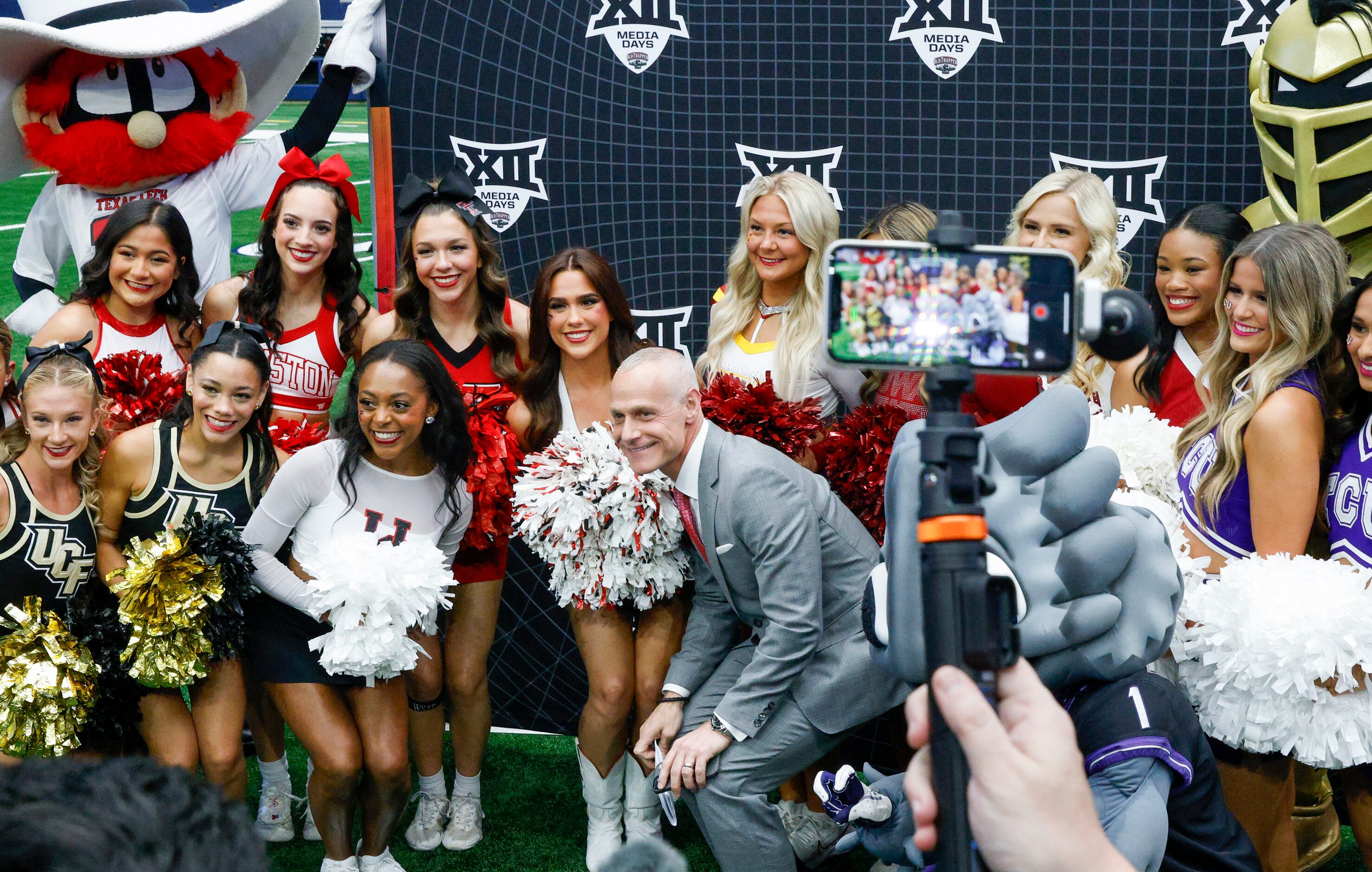 Big 12 commissioner Brett Yormark (center) poses for a photo with cheerleaders and mascots...