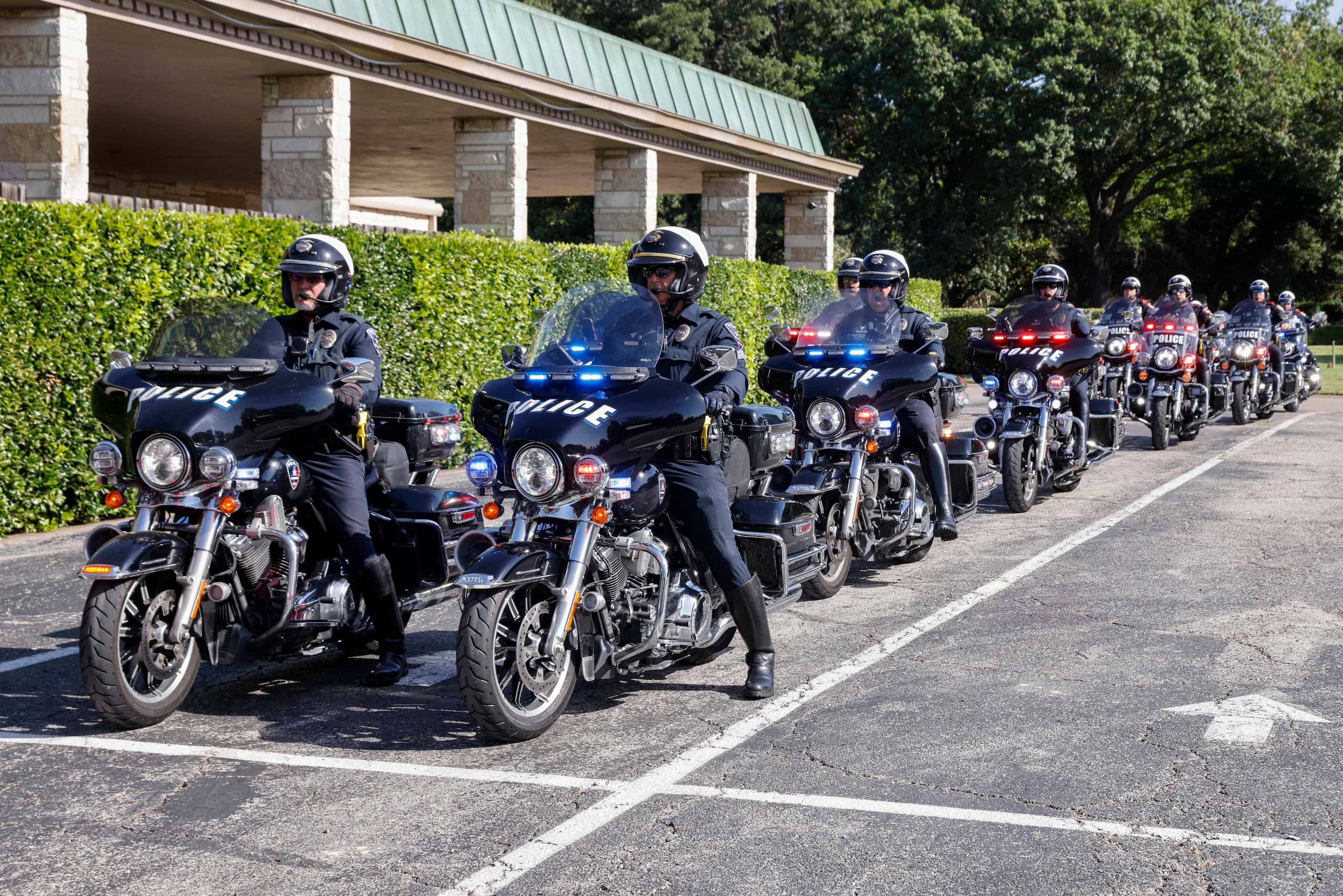Motorcycle police officers arrive as part of a processional for a funeral service for former...