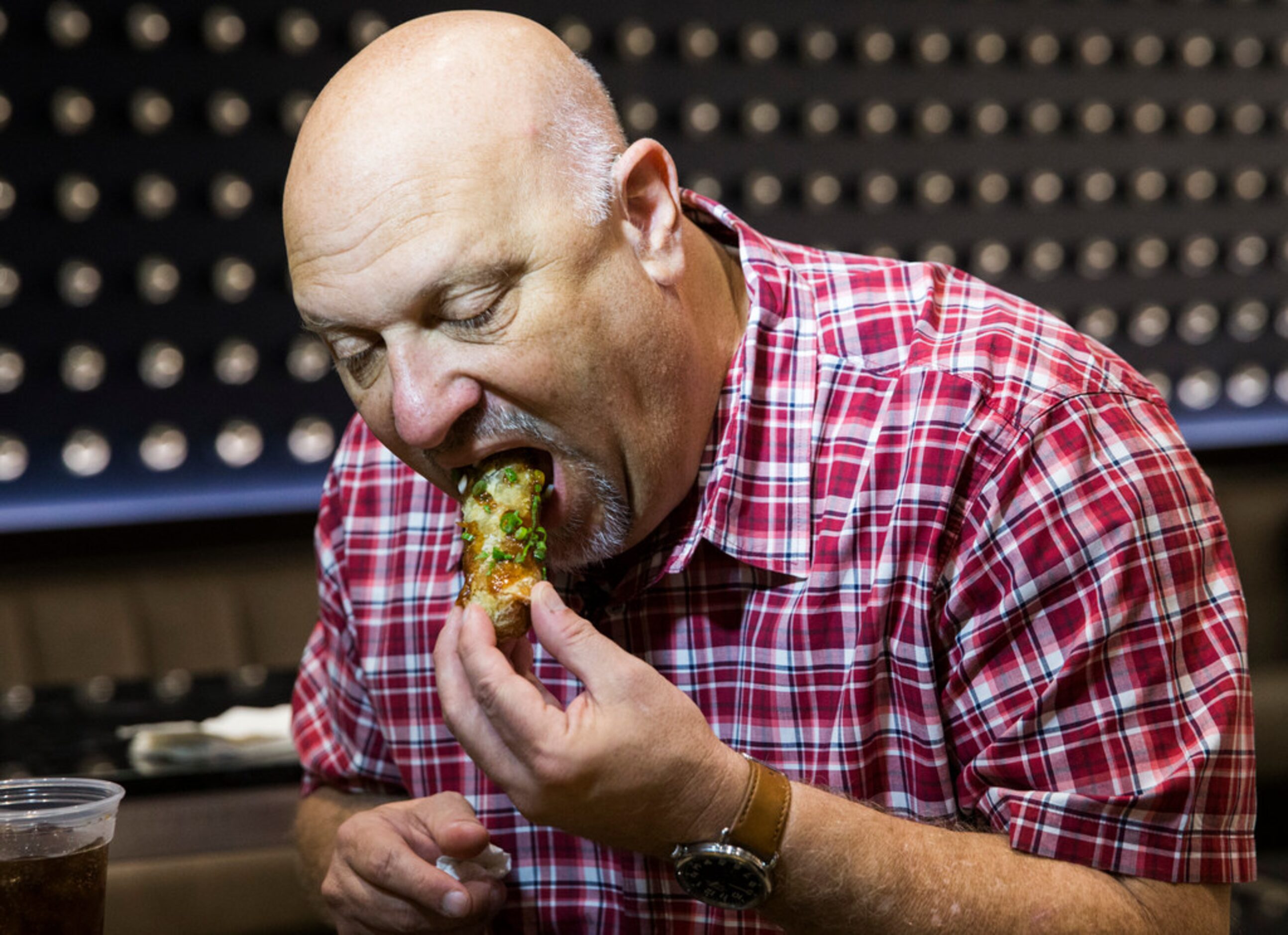 The Dallas Morning News' Evan Grant samples a brisket egg roll, a new concession stand item,...