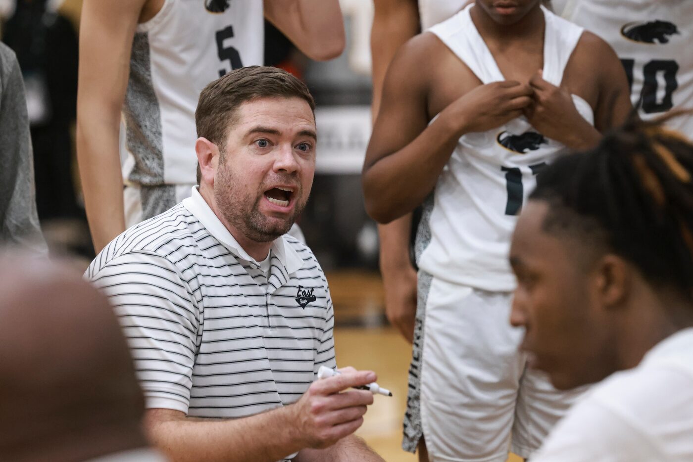 Plano East Senior High’s head coach Matt Wester talks to the team during a break in play at...