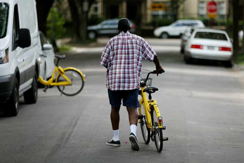 Maurice Clark, a rebalance technician with bike sharing company ofo, rebalances bicycles...