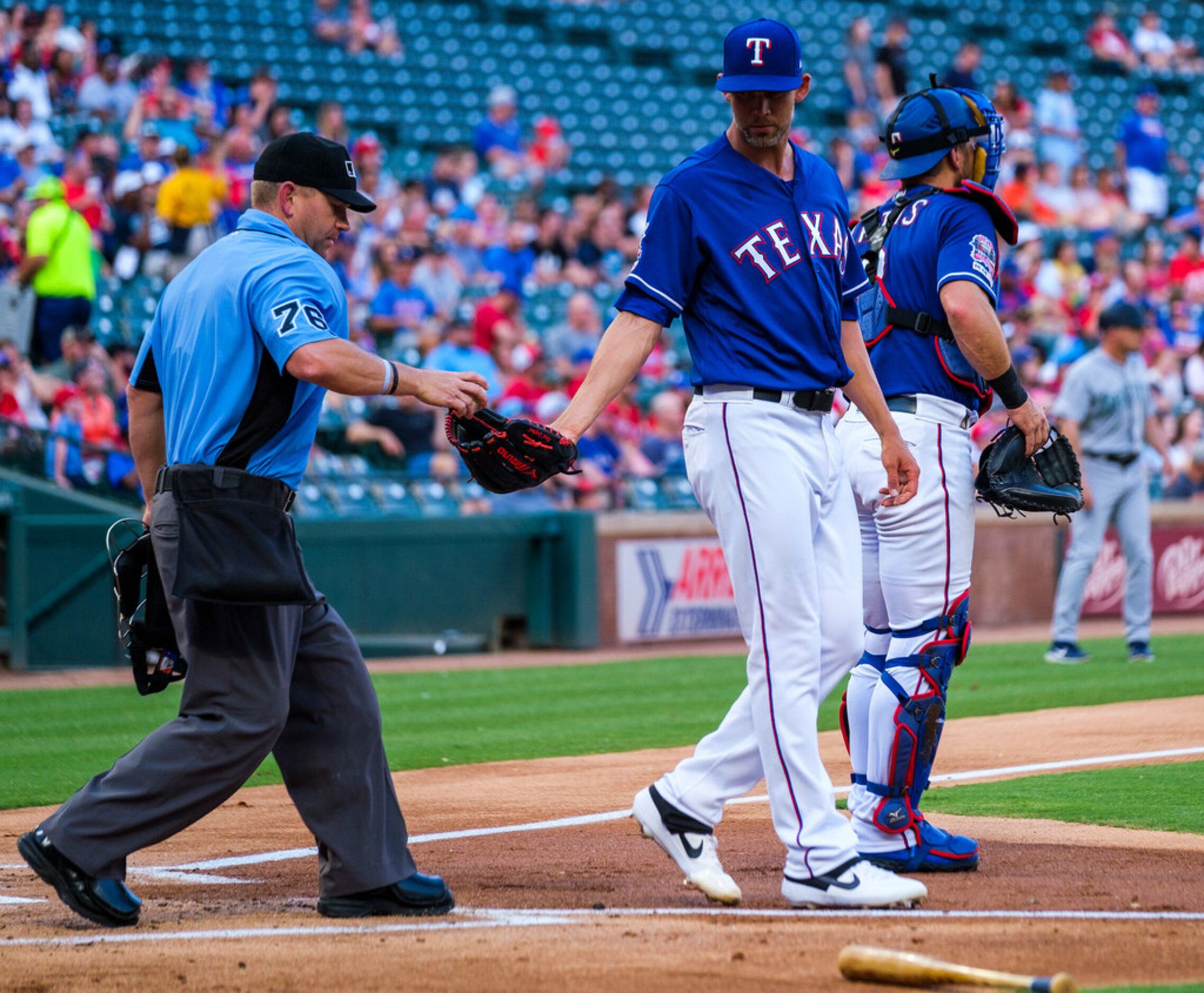 Texas Rangers starting pitcher Mike Minor gets a new ball from umpire Mike Muchlinski after...