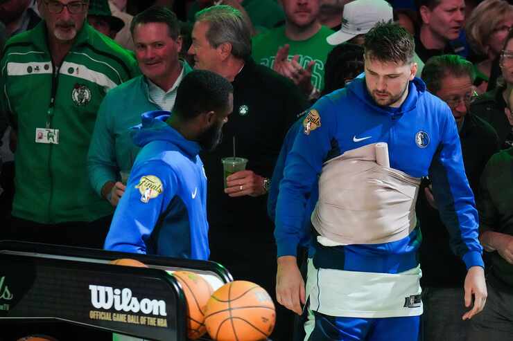 Dallas Mavericks guard Luka Doncic wears a wrap around his chest during the national anthem...