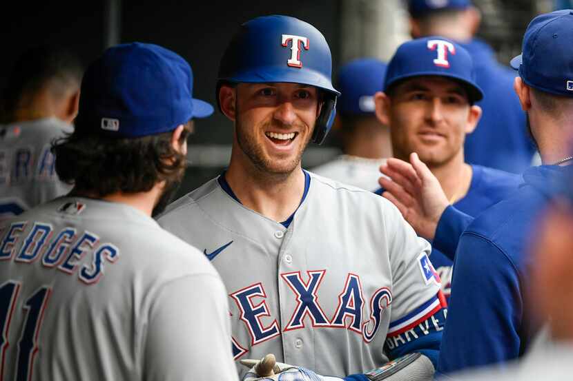 Texas Rangers' Mitch Garver celebrates in the dugout after hitting a home run against the...