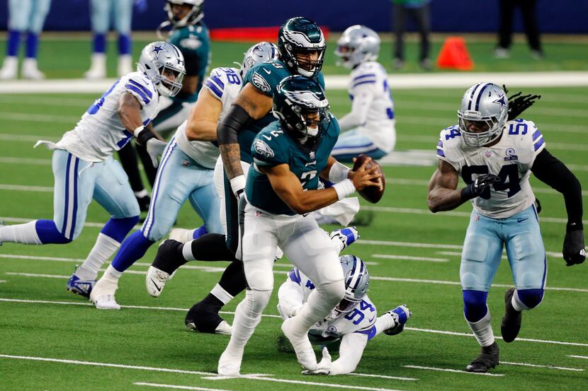 Philadelphia Eagles quarterback Jalen Hurts (2) is boxed in by Dallas Cowboys defensive end...