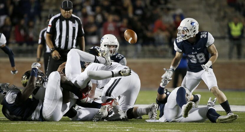 Plano East quarterback Miklo Smalls (1) fumbles the ball after being tackled by Allen's Levi...