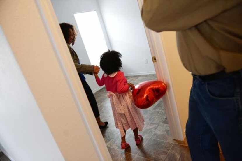 
Ethiopia Tuffa leads her daughter Hamera, 4, into her new bedroom during dedication...