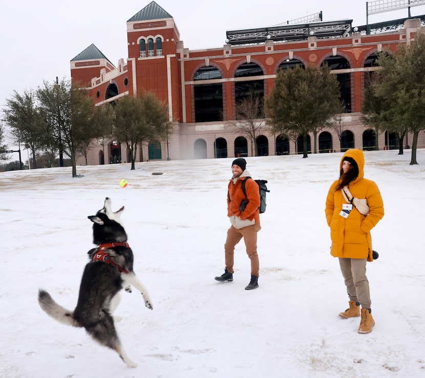 After a band of sleet dropped about 2 inches of sleet in Arlington, Eve Godat (right) and...