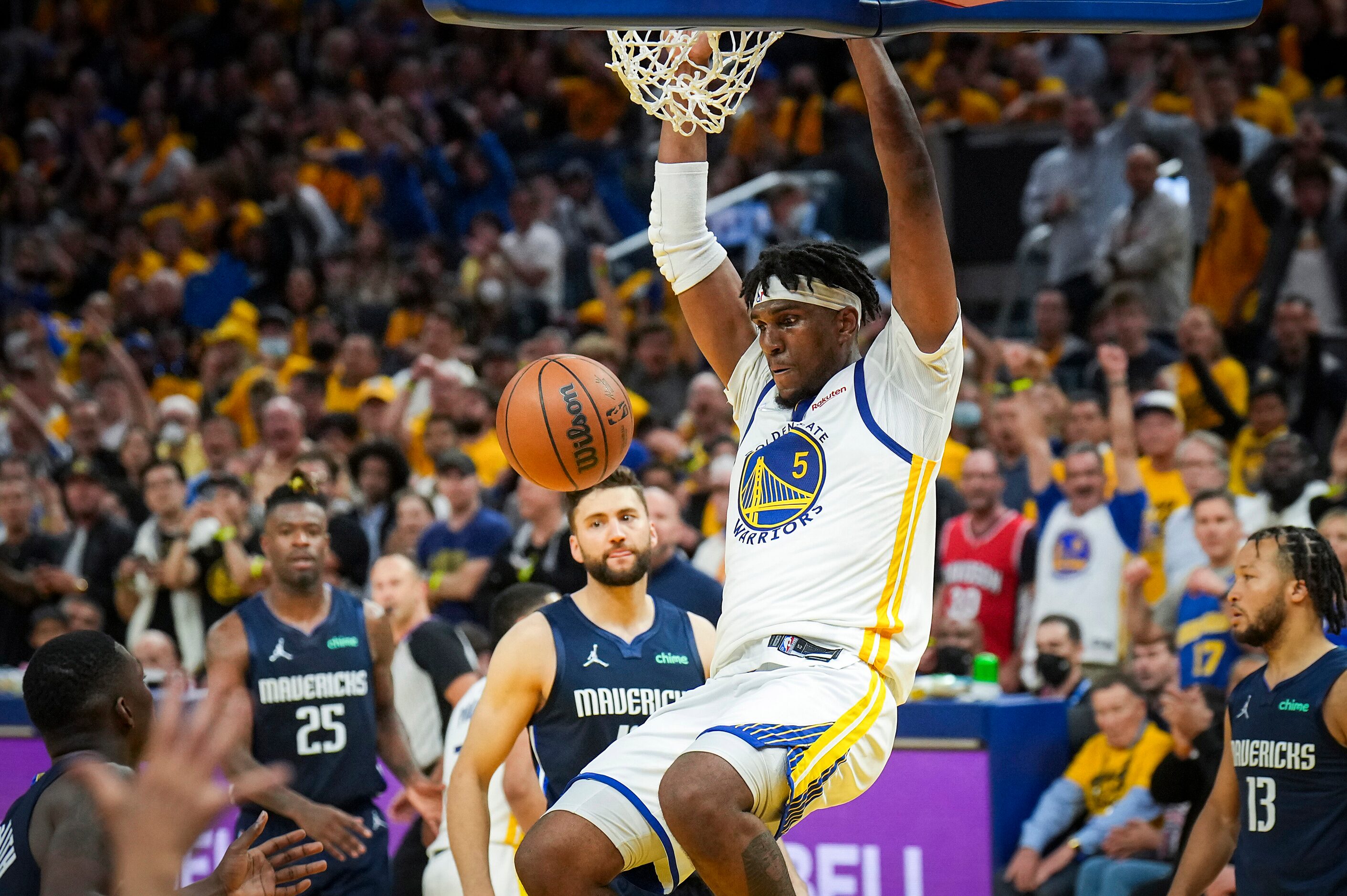 Golden State Warriors center Kevon Looney (5) dunks the ball past Dallas Mavericks forward...