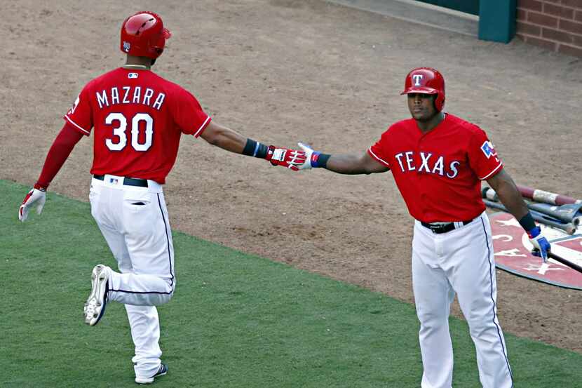 Texas Rangers right fielder Nomar Mazara (30) high-fives third baseman Adrian Beltre after...