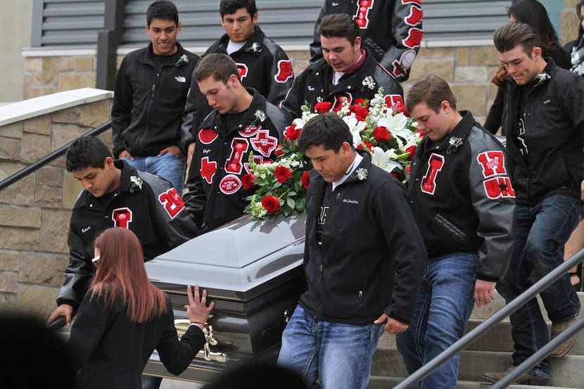 Iraan Braves' senior football players carry Liz Pope's casket to the the hearse after her...