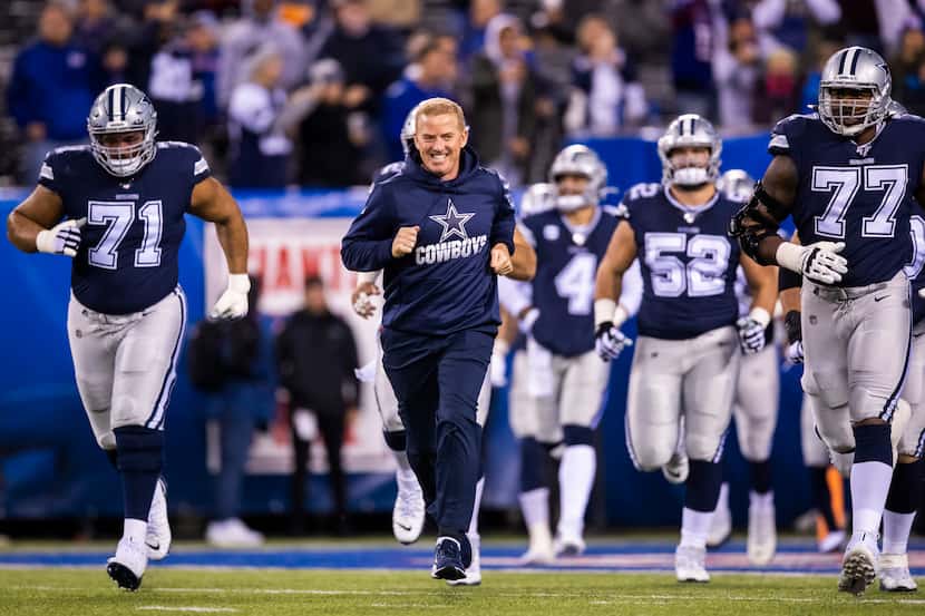 Dallas Cowboys head coach Jason Garrett runs out with his team before an NFL game between...