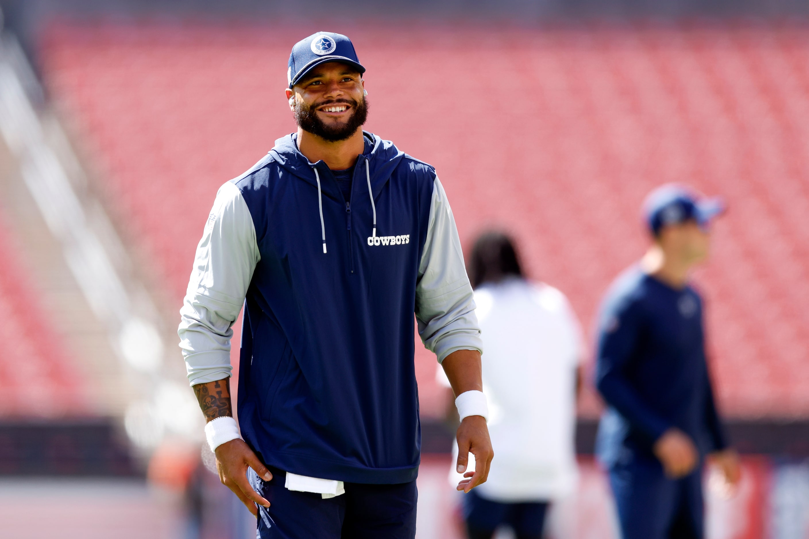 Dallas Cowboys quarterback Dak Prescott smiles as he warms up before a game against the...