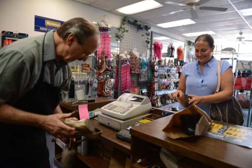 
Amy Farrell pays Kenneth Burks for a shoe repair at Messina Shoe Repair in Farmers Branch....