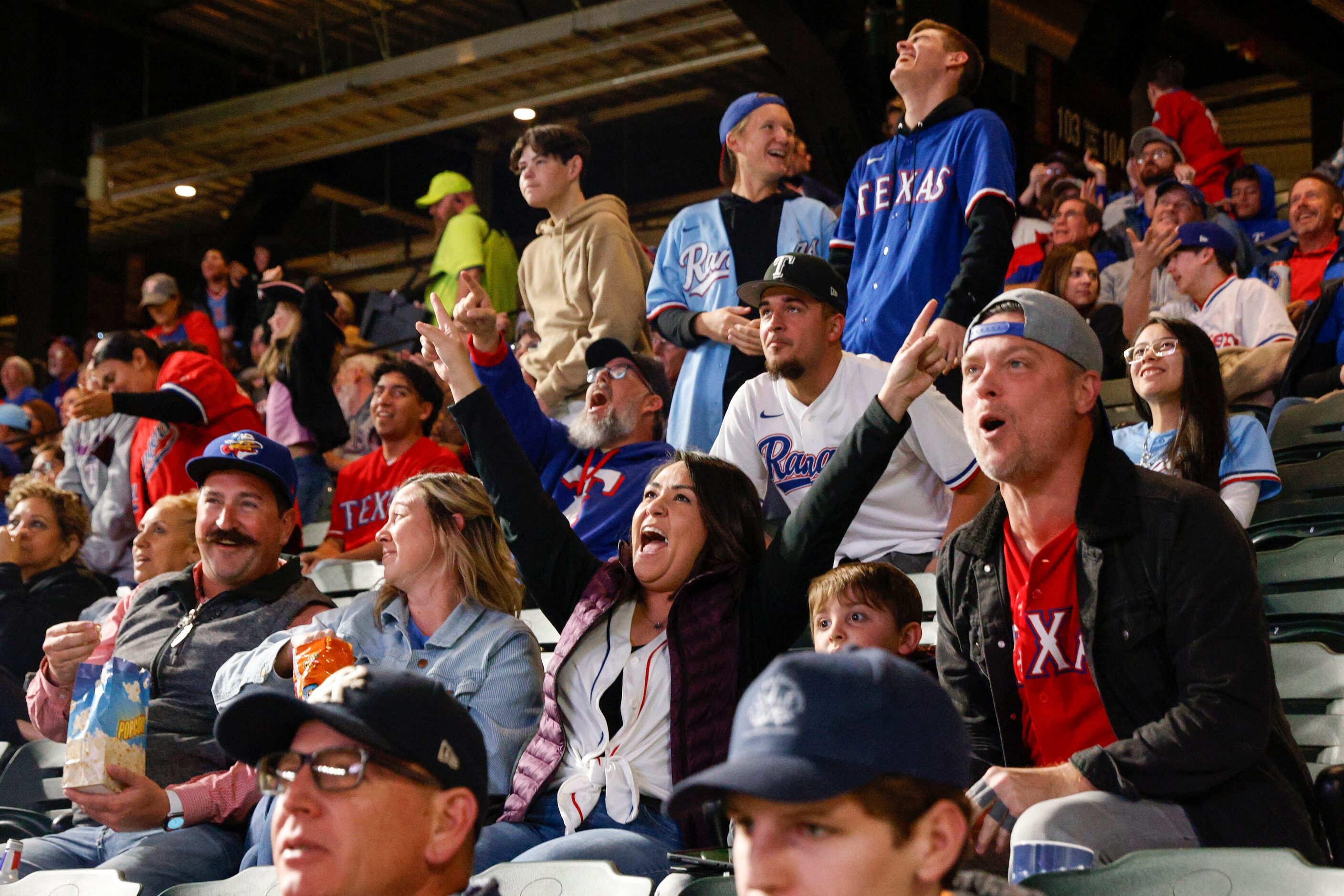 Texas Rangers fans cheer after right fielder Adolis Garcia threw out an Arizona Diamondbacks...