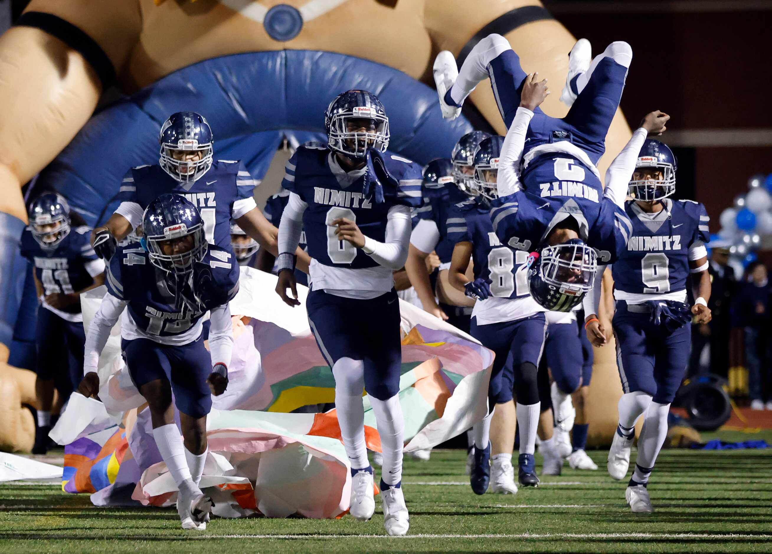 Irving Nimitz's Mykhi Toney (3, right) does a back flip as he and his teammates run onto the...